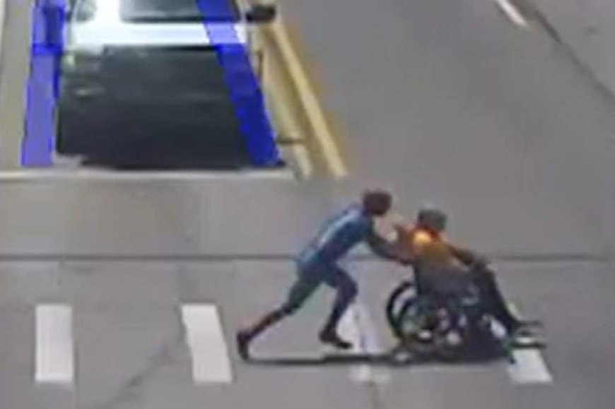 Man in Spider-Man suit helps wheelchair user cross busy intersection
