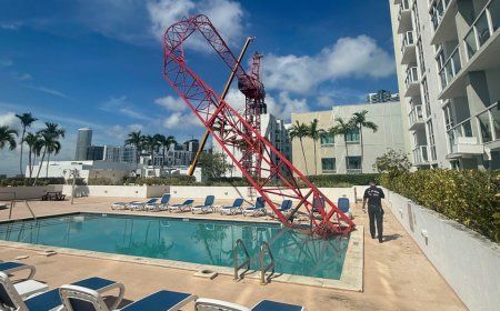 Crane arm collapses into Miami condo rooftop pool area as workers cling to dangling structure